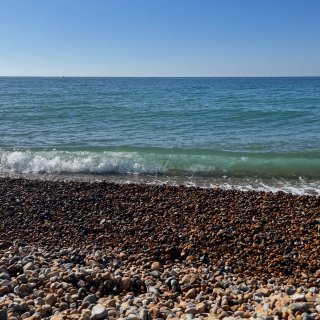Glassy green water catching the sun on Brighton beach.