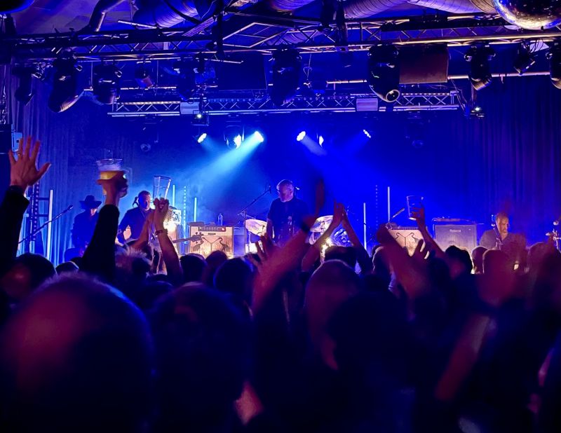 The band on stage in front of an enthusiastic audience.